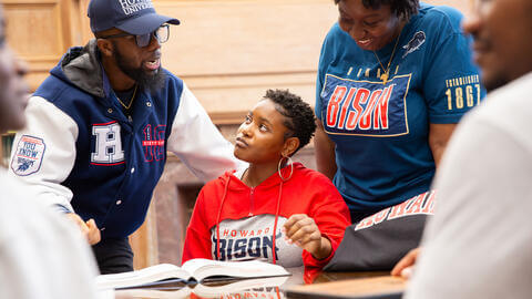 Smiling faculty mentoring a student wearing Howard University clothing