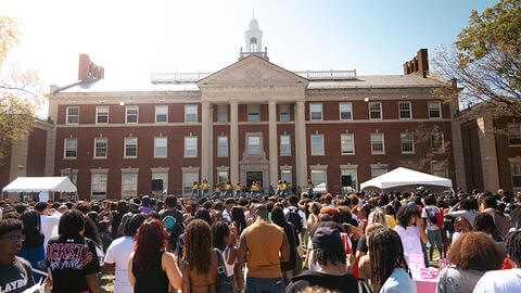 Crowd of students, faculty and staff standing in front of Frederick Douglass Memorial Hall